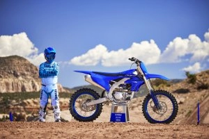 YZ450F Team Yamaha Blue on stand with rider next to it