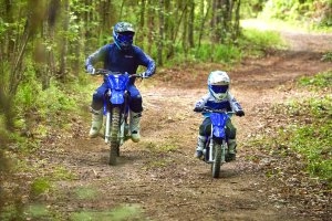 Man and kid riding in the woods 1