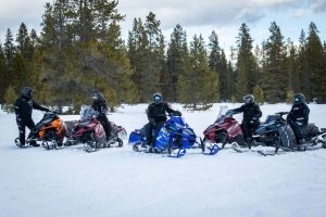 Riders on 5 snowmobiles in the snow